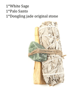 A natural wood support holding up an abalone shell with a sage stick with a feather placed beside
